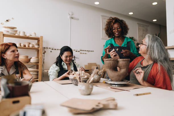 istock Pottery teacher teaching her student at a ceramics workshop 1884766210