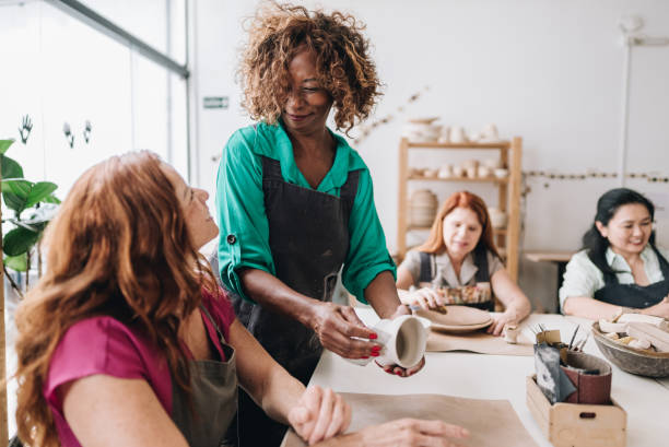 istock Pottery teacher teaching her student at a ceramics workshop 1884766341