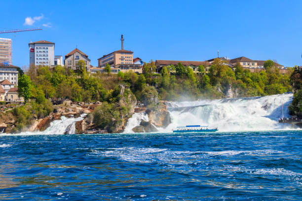 sightseeing boat with tourists sailing close to the rhine falls, most powerful waterfall in europe - 5905 стоковые фото и изображения