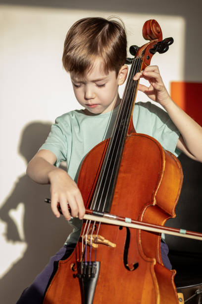 istock 6 year old boy playing cello at home 1884785236