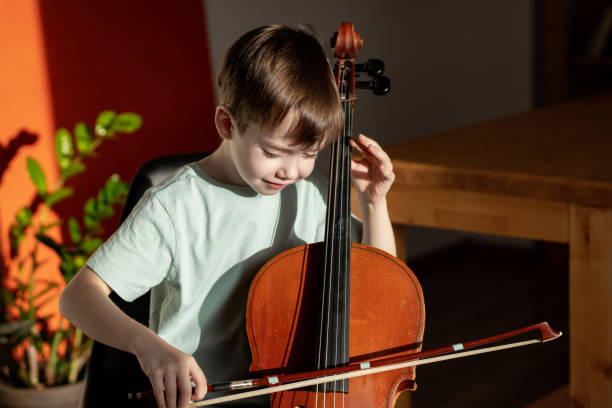istock 6 year old boy playing cello at home 1884792525