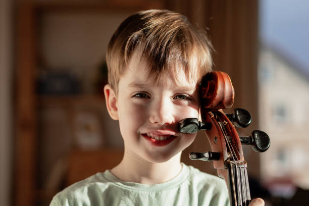 6 year old boy playing cello at home