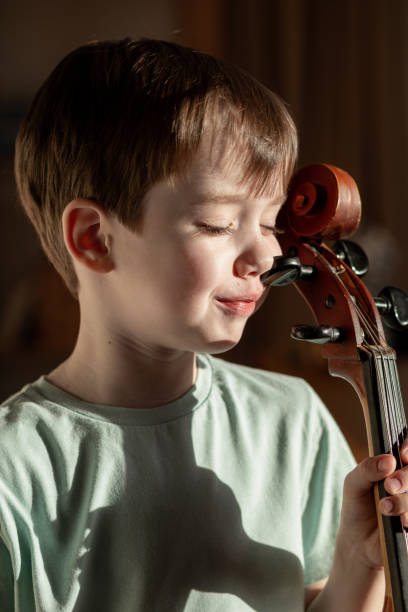istock 6 year old boy playing cello at home 1884800654