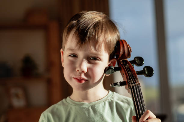 istock 6 year old boy playing cello at home 1884802198