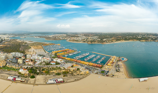 Portimao, Portugal: October 09 2022: Aerial perspective of Portimao Marina. Luxury yacht docked in the port. Arade river in the middle. Famous travel destination situated in South of Portugal, Algarve