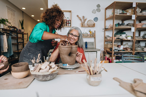 Pottery teacher teaching student at a ceramics workshop