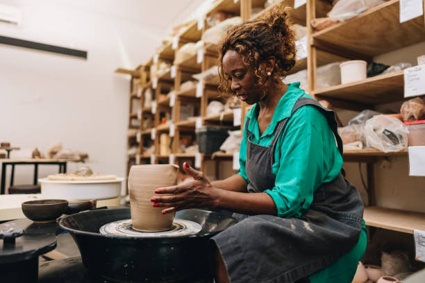 Senior woman making a vase on a ceramics workshop