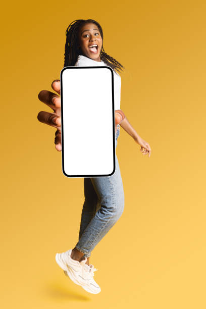 istock Excited attractive young 20s woman showing smartphone with empty blank screen isolated on yellow 1884852021