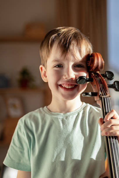istock 6 year old boy playing cello at home 1884871764