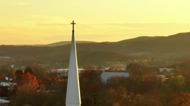 Birds Perch On Cross Atop Church Steeple On An Autumn Morning In Fayetteville, Arkansas. aerial shot