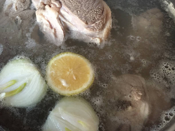 Meat bone with vegetables boiling in a saucepan