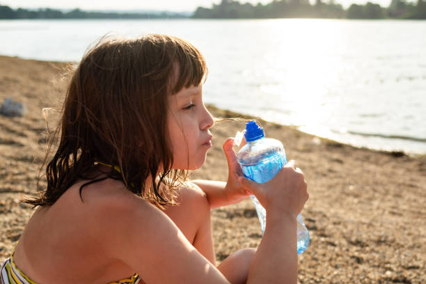 Child holding glasses of water in nature