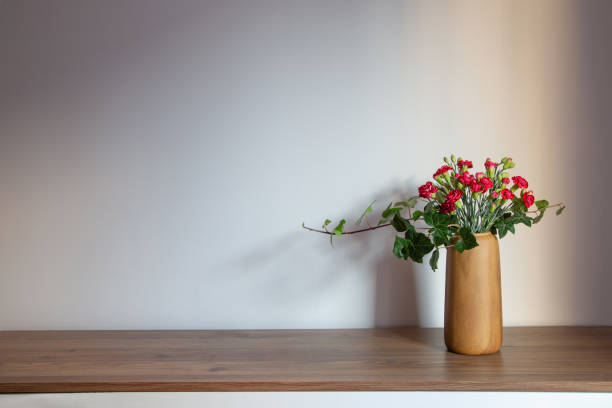 istock red carnations  in modern vases on background gray wall 1884912849