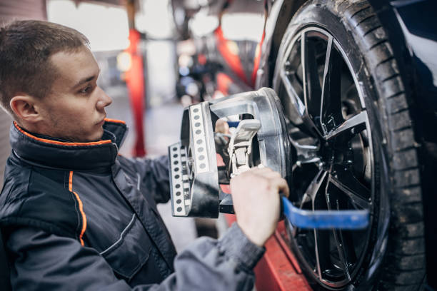 istock Mechanic sets the wheel alignment equipment on a car wheel 1884921812
