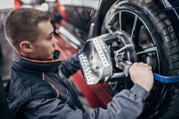 istock Mechanic sets the wheel alignment equipment on a car wheel 1884922848