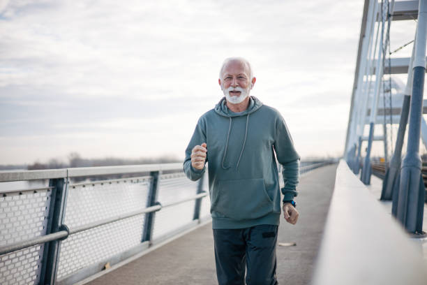 istock Senior man jogging on bridge 1884953969