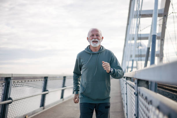 istock Senior man jogging on bridge 1884953971