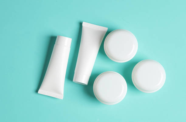 istock White cream jars and tubes on a blue background. Mockup, template for design. Top view 1884960320