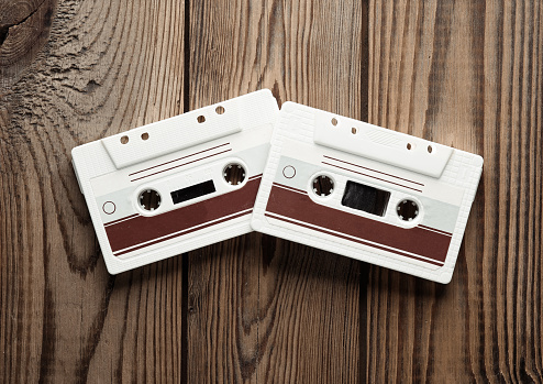 Retro 80s audio cassettes on wooden background. Music concept, vintage technology. Top view.
