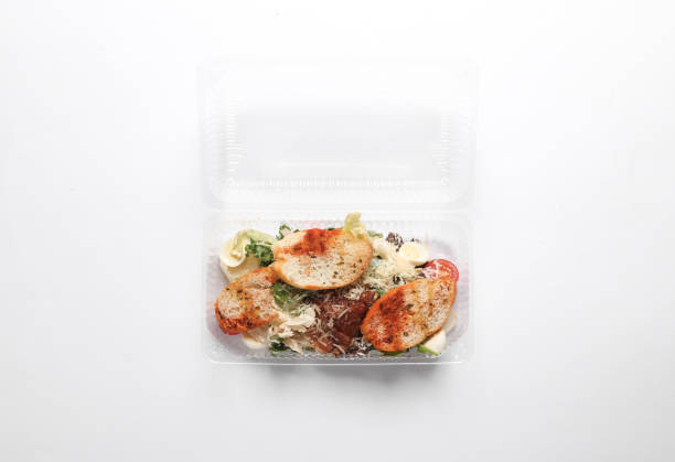 Salads in a plastic box on a white background. Tekaway food. Top view
