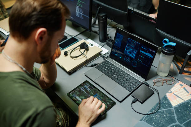 istock High angle of young serious male officer using tablet and laptop 1884973738