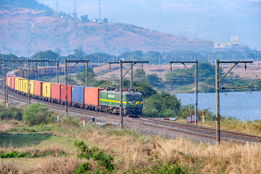 Pune, India - December 24 2023: Container freight train hauled by a WAG9 electric locomotive near Pune India.