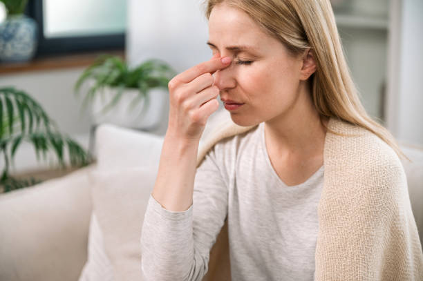 istock woman with headache touching her nose bridge and feeling tired 1884989454