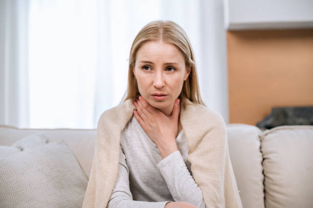 istock young sad woman with throat sore feeling unwell 1884989455