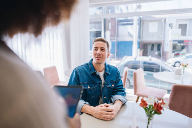 istock Mature man ordering from the waitress at coffee shop 1885003281