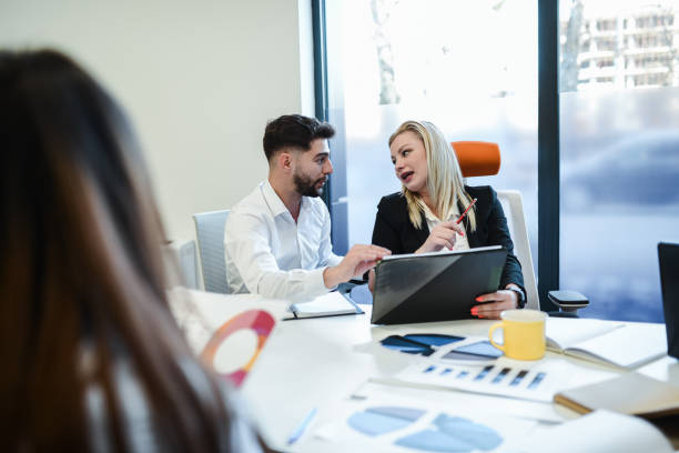 istock Male And Female Business Analysts Calculating Data Info During Meeting 1885018626