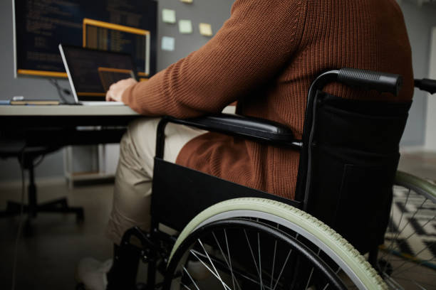 istock Close Up of Man with Disability Using Wheelchair Working at Desk 1885056038