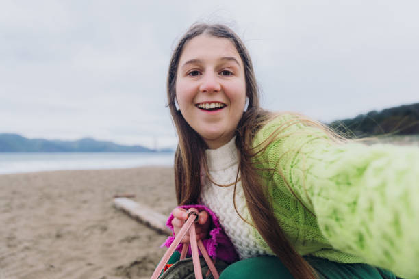 selfie d’une femme heureuse contemplant baker beach à san francisco, en californie, en écoutant de la musique - golden gate bridge audio photos et images de collection