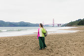 Woman with Backpack Contemplating Baker Beach in San Francisco, California