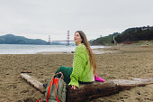 Happy Woman Contemplating Baker Beach in San Francisco, California Listening to Music