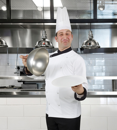 Chef presenting an empty plate  in a commercial kitchen