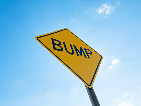 Looking up to a bump sign in front of a blue sky