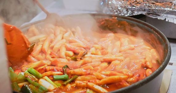close up vendor cooking tteokbokki spicy fried rice cake - asia travel in korea seoul myeongdong