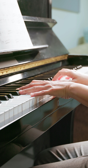 Closeup hands of asian woman playing piano
