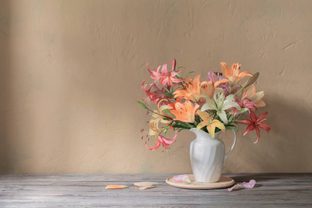 istock beautiful lily in white jug on wooden table 1885116973