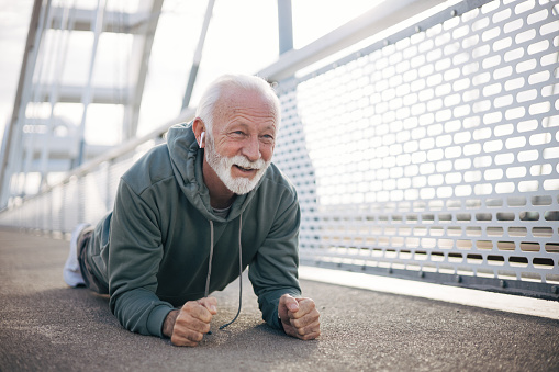 Active senior man in a plank pose on bridge