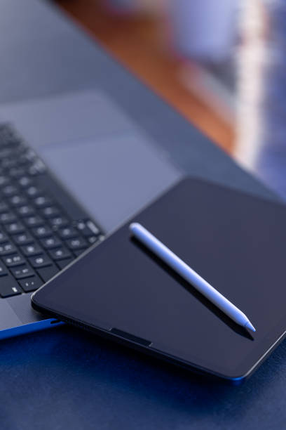 Digital tablet, stylus pen and laptop on the desktop, close up.