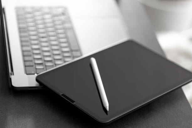 istock Digital tablet, stylus pen and laptop on the desktop, close up. 1885162073