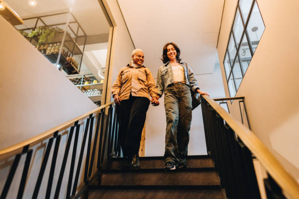 istock Lesbian couple moving down staircase 1885163730