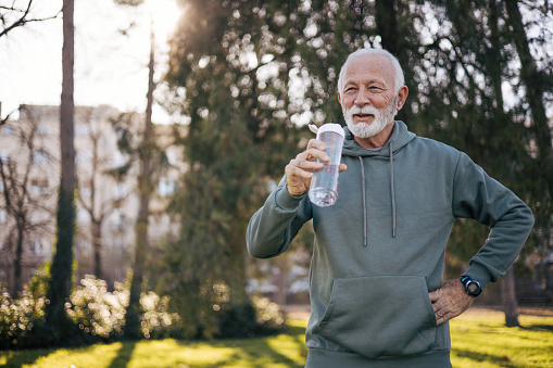 Senior man drinking water and resting after workout