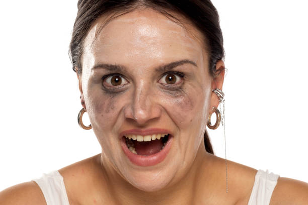 Crazy smiling woman with smeared make-up on a white background Crazy smiling woman with smeared make-up on a white studio background woman mascara smudged stock pictures, royalty-free photos & images