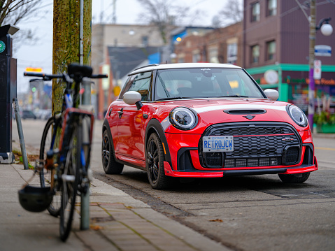 Amsterdam, The Netherlands - May 8, 2016: Street in Amsterdam, Amsterdam-Oost, and a new model of a BMW MINI Cooper S F56 parked on the street with Dutch plates. Other cars and buildings can be seen in the background. 
