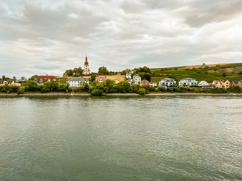 Traveling along the Rhine River with scenic views of the medieval town of Trebur, Germany. Views of colorful European style architecture and vineyards on the sloping land. Trebur is a small town that offers a unique blend of natural beauty, rich history, and vibrant culture