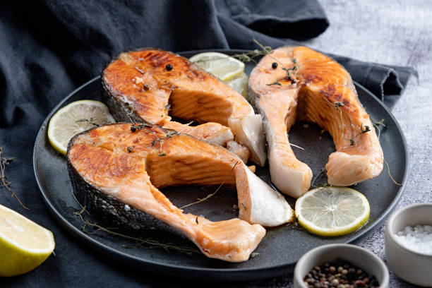 istock Stake Fish trout with lemon and spices on dark background 1885285196
