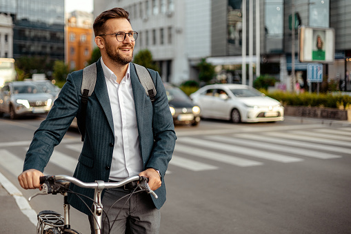 Shot of a Businessman with Backpack Commuting to Work With His Bicycle in City center. Urban ecological transport