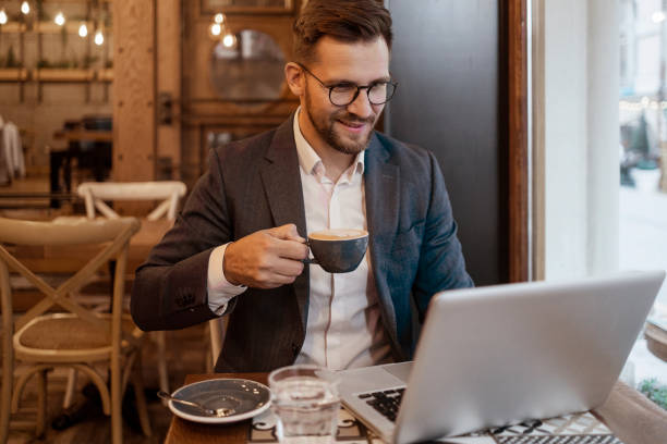 istock Man with Coffee and Laptop Sitting at Cafe 1885290885